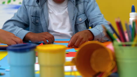 Cute-little-boy-using-glue-in-classroom