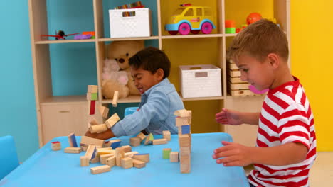 Cute-little-boys-playing-with-building-blocks-at-table-in-classroom