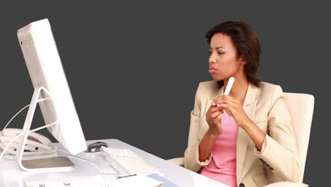 Businesswoman-filing-her-nails-at-her-desk