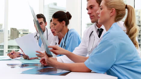 Equipo-Médico-Mirando-Radiografías-Y-Archivos-Durante-La-Reunión