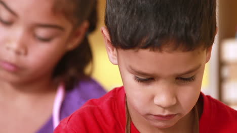 Preschool-class-painting-at-table-in-classroom