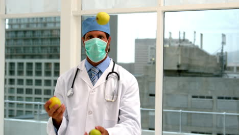 Arzt-Mit-Maske-Jongliert-Mit-Grünen-Äpfeln