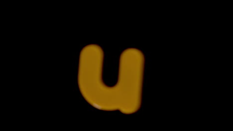 The-letter-u-coming-into-focus-on-black-background