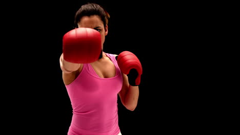 Fit-young-woman-punching-at-camera-on-black-background