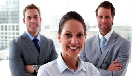 Confident-business-team-smiling-at-camera