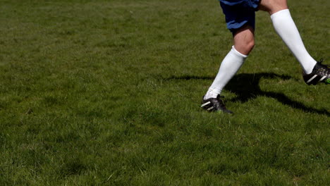 Football-player-kicking-the-ball-on-grass