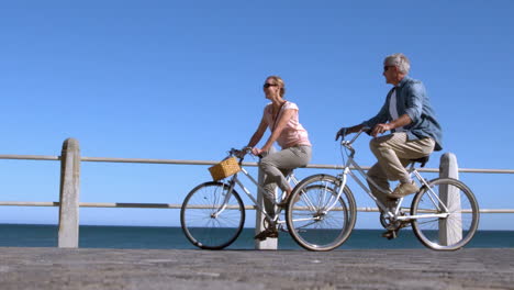 Senior-couple-going-on-a-bike-ride-in-the-city-on-the-pier