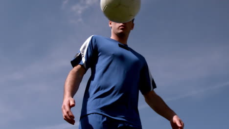Football-Spieler,-Der-Den-Ball-Unter-Blauem-Himmel-Kontrolliert