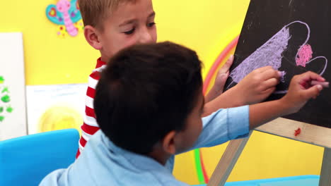 Cute-little-boys-drawing-on-mini-chalkboard