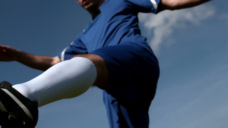 Football-player-kicking-the-ball-under-blue-sky