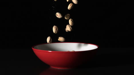 Pistachio-nuts-falling-in-red-bowl