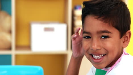 Cute-little-boy-painting-at-table-in-classroom