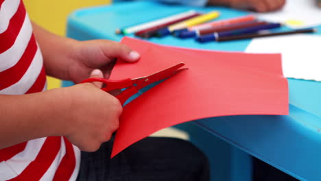 Niedlicher-Kleiner-Junge-Schneidet-Papierformen-Im-Klassenzimmer