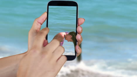 Mano-Que-Muestra-Clips-De-Playa-Y-Vacaciones-En-El-Teléfono-Inteligente