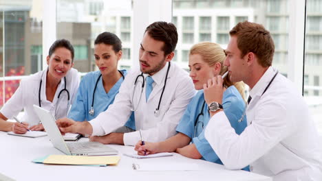 Equipo-Médico-Mirando-La-Computadora-Portátil-Durante-La-Reunión