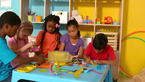 Cute-little-pupils-playing-with-modelling-clay-in-classroom