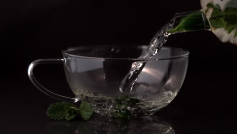 Teapot-pouring-mint-tea-into-glass-cup