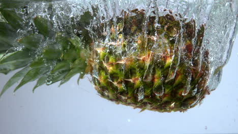Pineapple-falling-in-water-on-white-background