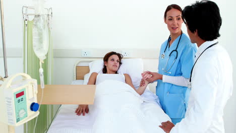 Doctor-and-nurse-checking-sick-patient-in-bed