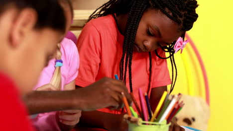 Preschool-class-drawing-at-table-in-classroom