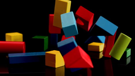 Building-blocks-falling-and-bouncing-on-black-background