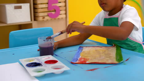 Cute-little-boys-painting-at-table-in-classroom