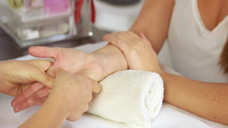 Beauty-therapist-massaging-customers-hand