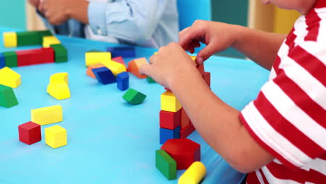 Lindos-Niños-Jugando-Con-Bloques-De-Construcción-En-La-Mesa