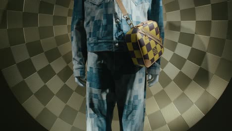 Stylish-mannequin-in-blue-patchwork-attire-with-checkered-backdrop
