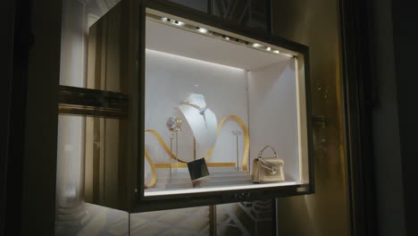 Luxurious-jewelry-and-handbag-display-in-an-illuminated-showcase-window