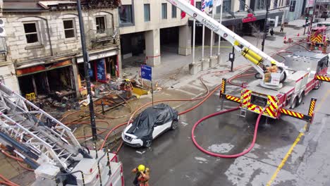 Aerial-drone-shot-at-the-scene-of-a-residential-apartment-fire-as-the-firefighters-continue-their-work-to-ensure-the-building-is-secure