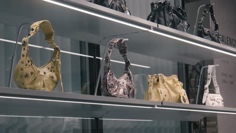 Close-up-of-luxury-handbags-on-illuminated-shelves-in-a-stylish-Venice-boutique