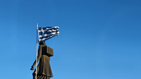 Bandera-Griega-Ondeando-Al-Viento-En-El-Monumento-A-Las-Mujeres-Zagorianas-De-Pindos.