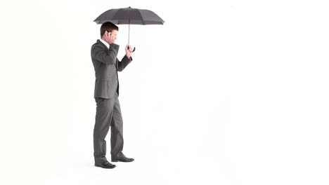 Businessman-opening-umbrella-and-talking-on-phone