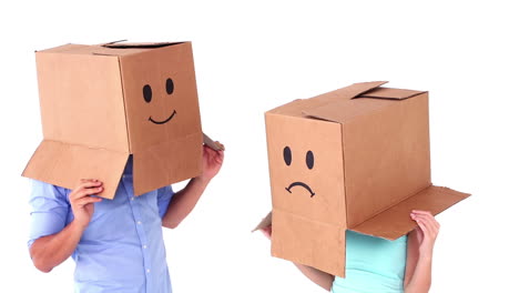 Pareja-Joven,-Llevando,-Cajas-De-Emoticonos,-En,-Cabezas