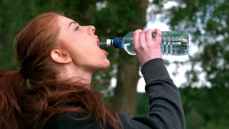 Pelirroja-Bebiendo-Agua-De-Una-Botella-Afuera