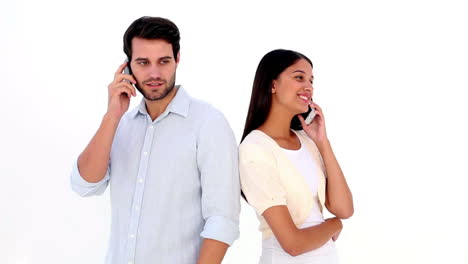 Attractive-young-couple-talking-on-phones