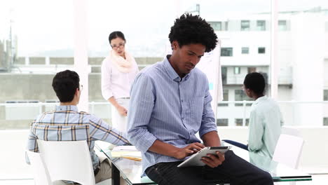 Equipo-De-Negocios-Creativo-Teniendo-Una-Reunión-Mientras-El-Hombre-Usa-Tablet-Pc