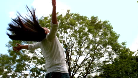Carefree-brunette-tossing-hair-in-the-park
