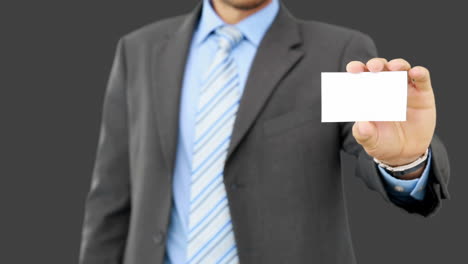 Young-businessman-showing-card-to-camera