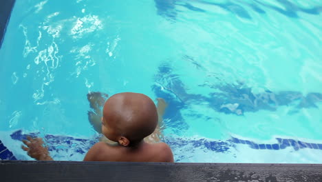 Lindo-Niño-Remando-En-La-Piscina