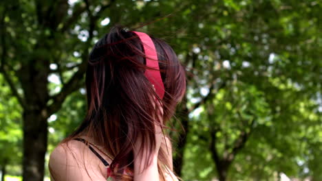 Pretty-asian-girl-listening-to-music-in-the-park