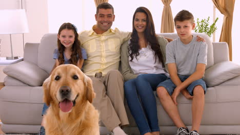 Happy-family-smiling-with-their-dog