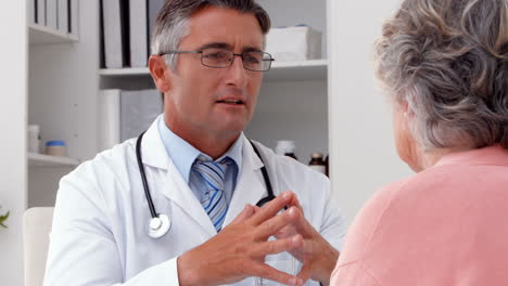 Doctor-speaking-with-his-patient-at-desk