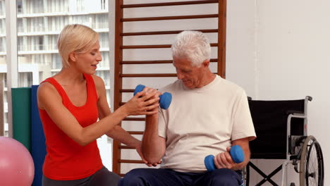 Trainer-helping-senior-citizen-work-out