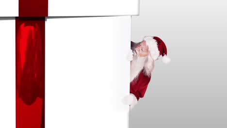 Santa-peeking-around-a-christmas-gift