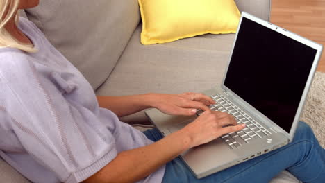 Mujer-Usando-Laptop-En-El-Sofá