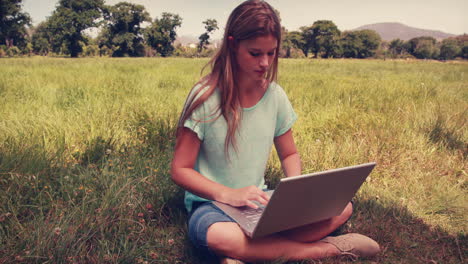 Pretty-blonde-relaxing-in-the-park-with-her-laptop