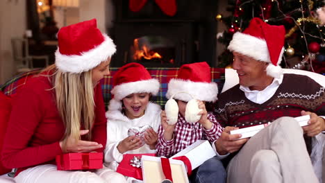 Glückliche-Familie-öffnet-Weihnachtsgeschenke