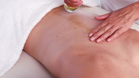 Masseuse-pouring-oil-for-massage